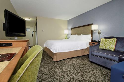 a hotel room with a bed and a flat screen tv at Hampton by Hilton Austin South - I-35 & Ben White in Austin