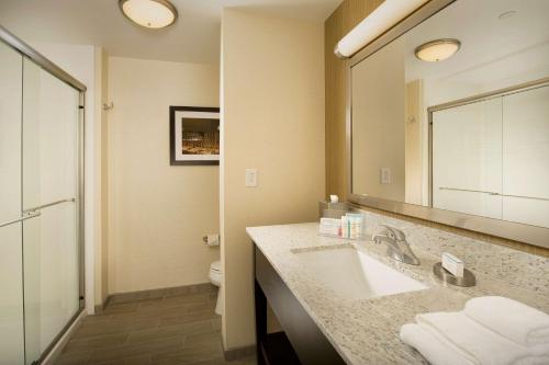 ein Badezimmer mit einem Waschbecken, einem WC und einem Spiegel in der Unterkunft Hampton Inn & Suites Baltimore/Woodlawn in Baltimore