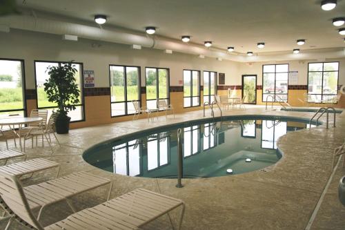 una piscina en un edificio con sillas y mesa en Hampton Inn and Suites Alexandria, en Alexandria