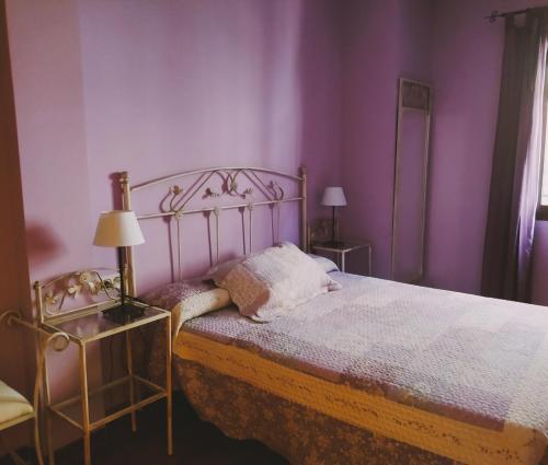 1 dormitorio con 1 cama con paredes moradas en El Balcon De Cabezuela Valle del Jerte, en Cabezuela del Valle