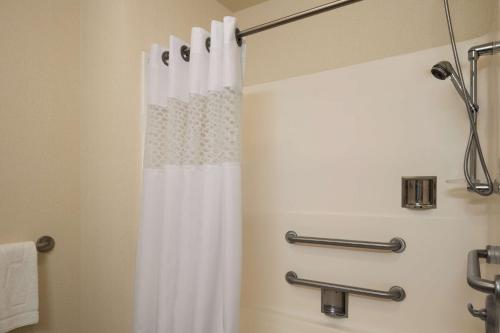 a shower with a white shower curtain in a bathroom at Hampton Inn Belle Vernon in Belle Vernon