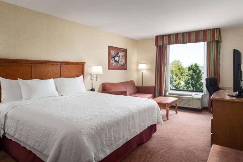 um quarto de hotel com uma cama e uma janela em Hampton Inn Belle Vernon em Belle Vernon
