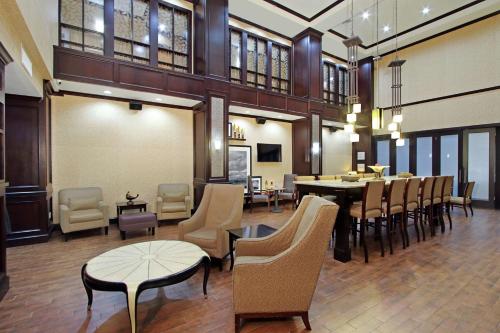 a lobby with a restaurant with chairs and a table at Hampton Inn & Suites Buffalo in Buffalo