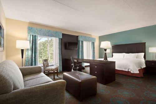 ein Hotelzimmer mit einem Bett und einem Schreibtisch in der Unterkunft Hampton Inn & Suites Bluffton-Sun City in Bluffton