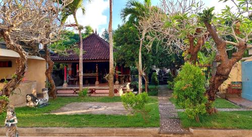 a house with a garden with trees in front of it at Goa Ganesha in Nusa Dua