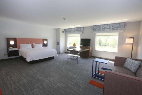 Habitación de hotel con cama y sofá en Hampton Inn Owego en Owego