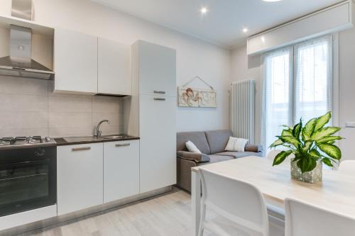 a kitchen with white cabinets and a table with a plant at La Corte dei Mari in Cesenatico