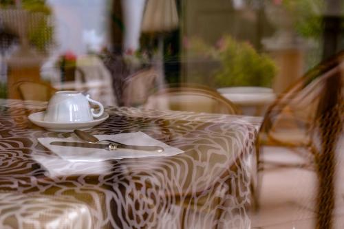 a table with a tea pot on top of it at Hotel Bellevue in Gardone Riviera