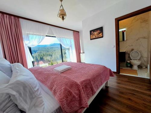 sypialnia z łóżkiem i dużym oknem w obiekcie Conacul Munții Bucovinei w mieście Kimpulung Mołdawski