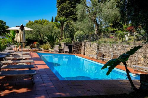 a swimming pool with lounge chairs and an umbrella at Hotel Bellevue in Gardone Riviera