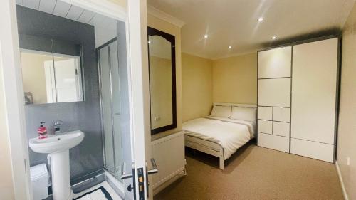 a bathroom with a sink and a bed in a room at Hana Holiday Home - 4 En-suite Bedroom house in Menai Bridge