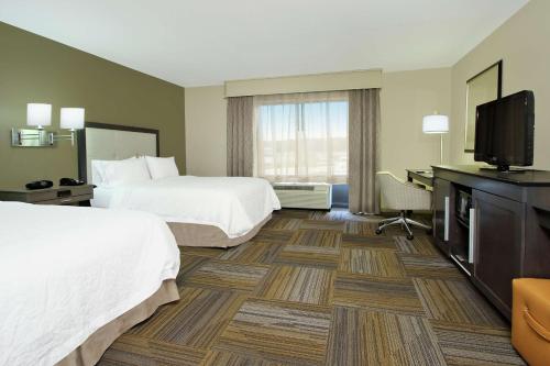 a hotel room with two beds and a flat screen tv at Hampton Inn Jasper, AL in Jasper