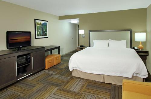 a hotel room with a bed and a flat screen tv at Hampton Inn Jasper, AL in Jasper