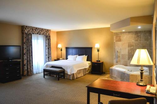 ビリングスにあるHampton Inn & Suites Billings West I-90のベッドとバスタブ付きの広いホテルルームです。