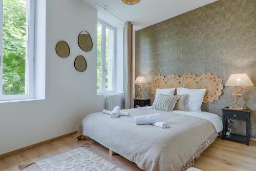 a bedroom with a large bed with two pillows at La Bouverie in Romans-sur-Isère