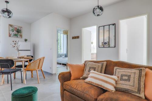 a living room with a brown couch and a table at La Bouverie in Romans-sur-Isère