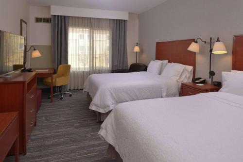 a hotel room with two beds and a desk at Hampton Inn and Suites Bakersfield North-Airport in Bakersfield