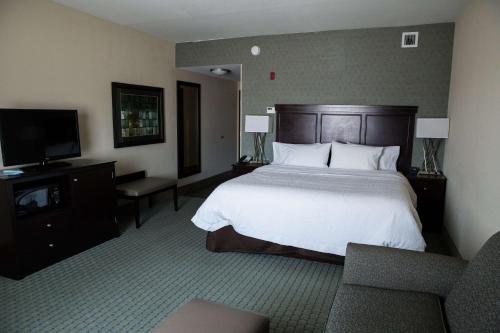 a hotel room with a bed and a flat screen tv at Hampton Inn & Suites Bismarck Northwest in Bismarck