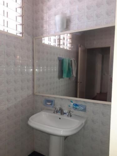 uma casa de banho com um lavatório branco e um espelho. em Habitación en peatonal de Concordia 25000 PESOS LA NOCHE em Concordia