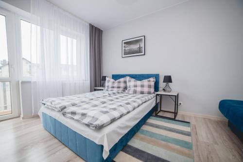 a bedroom with a blue bed and a window at Larapunta in Karwia