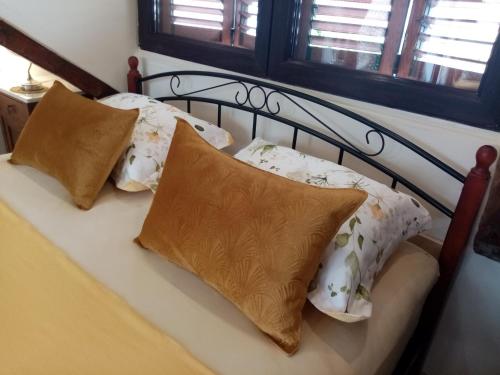 a bed with four pillows on it with a black frame at Apartments & Rooms Trogir Stars FREE PARKING in Trogir