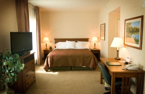 Habitación de hotel con cama y escritorio en Homewood Suites Bakersfield, en Bakersfield