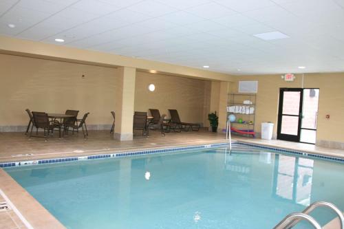 una piscina en una habitación de hotel con sillas y mesas en Hampton Inn & Suites Brookings, en Brookings
