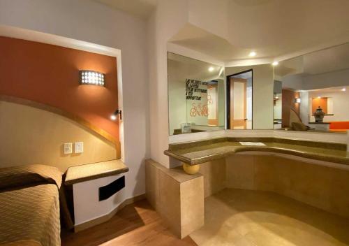 a bedroom with a bed and a bathtub and a sink at Hotel Villa de Madrid in Mexico City