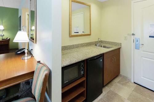 a kitchen with a sink and a desk with a microwave at Hampton Inn & Suites Blairsville in Blairsville