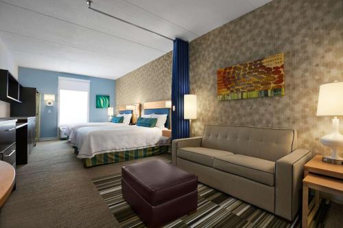 a hotel room with a bed and a couch at Home2 Suites Nashville Airport in Nashville
