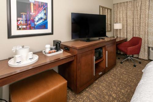 a hotel room with a television and a desk with a chair at Hampton Inn & Suites Nashville-Green Hills in Nashville