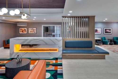 a lobby of a hotel with blue chairs and a table at Homewood Suites by Hilton Boston/Canton, MA in Canton