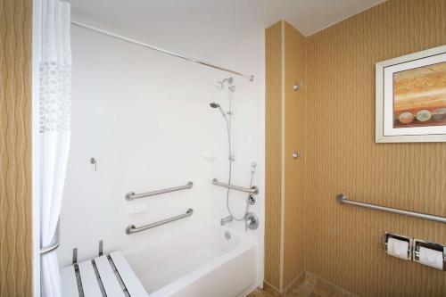 a bathroom with a shower and a white bath tub at Hampton Inn Haverhill in Haverhill