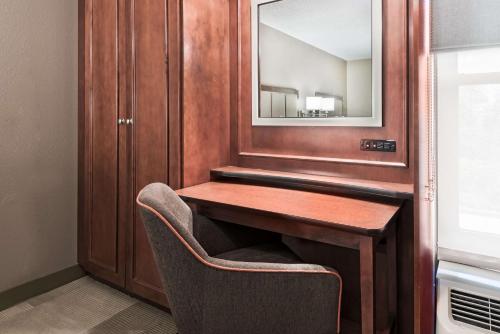 a vanity in a room with a chair and a mirror at Hampton Inn Boston / Marlborough in Marlborough