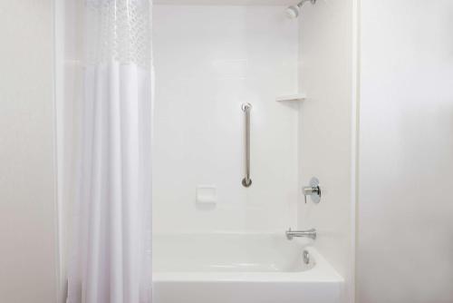a bathroom with a shower and a white tub at Hampton Inn Boston / Marlborough in Marlborough
