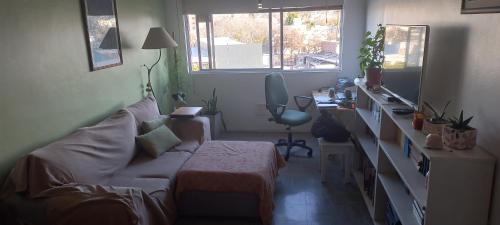 un soggiorno con divano, scrivania e finestra di Confortable Apartamento en Microcentro a Barraquero