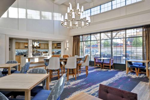 a dining room with tables and chairs and a chandelier at Homewood Suites by Hilton Boston - Peabody in Peabody