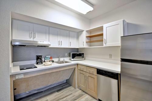 a kitchen with white cabinets and a stainless steel refrigerator at Homewood Suites by Hilton Boston - Peabody in Peabody