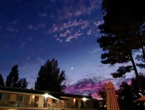a house at night with the moon in the sky at The Nook Pinetop in Pinetop-Lakeside