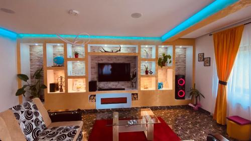 a living room with a couch and a tv at Casa dintre Brazi in Statjunea Borsa