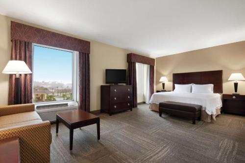 ブランズウィックにあるHampton Inn & Suites Brunswickのベッドと大きな窓が備わるホテルルームです。