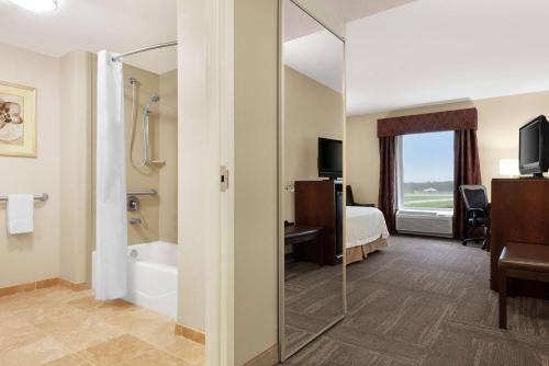 a hotel room with a bathroom with a tub and a bed at Hampton Inn & Suites Brunswick in Brunswick