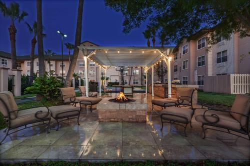 a patio with chairs and a fire pit in a courtyard at Homewood Suites by Hilton Brownsville in Brownsville