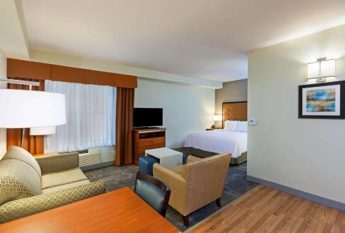 une chambre d'hôtel avec un lit et un salon dans l'établissement Homewood Suites by Hilton Brownsville, à Brownsville