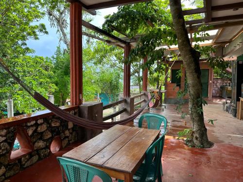 - une table et des chaises en bois sur une terrasse avec un arbre dans l'établissement Out Back Zapote, à Flores