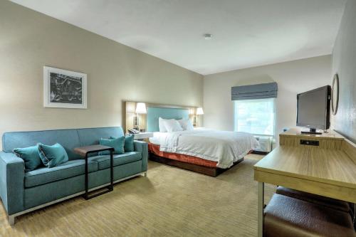 a hotel room with a bed and a couch at Hampton Inn Batavia in Batavia