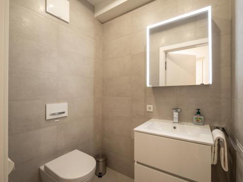 a bathroom with a toilet and a sink and a mirror at Herzi Chalet - top ausgestattet, neu, chic und sehr gemütlich in Walchsee
