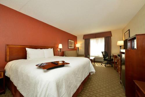 a hotel room with a large bed with a tray on it at Hampton Inn East Aurora in East Aurora