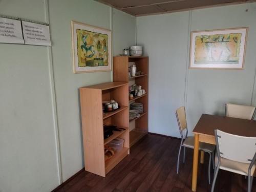 a dining room with a table and a book shelf at Chatová osada U Jaryna in Doksy
