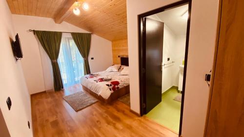 a bedroom with a bed and a large mirror at Casa dintre Brazi in Statjunea Borsa